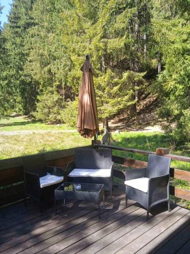 a patio with two chairs and an umbrella and a table at Котедж Арпад in Synevyr
