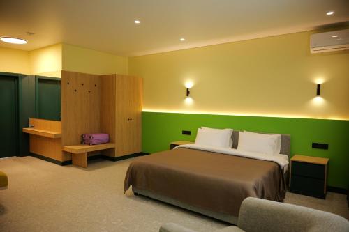a bedroom with a bed and a green wall at BVS Hotel in Ukrayinka