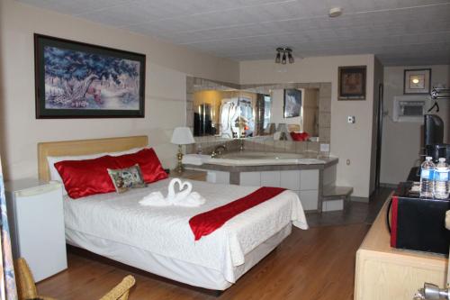 een slaapkamer met een bed en een badkamer met een bad bij Ritz Inn Niagara in Niagara Falls