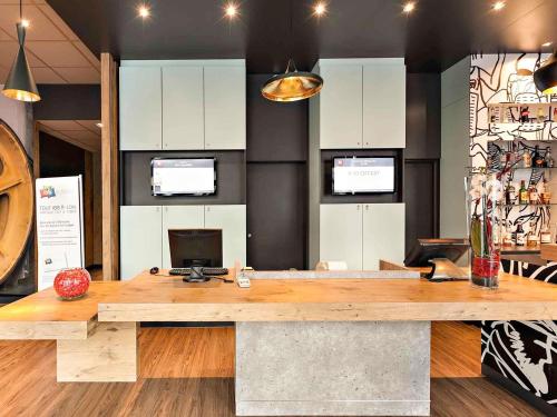 a large wooden desk in a room with white cabinets at Ibis Agen Centre - Rénové en 2026 in Agen