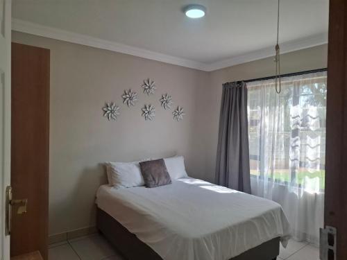 a bedroom with a bed and a window at CE Guesthouse in Vanderbijlpark