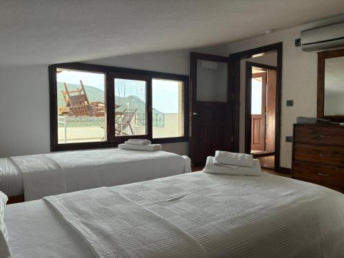 a bedroom with two beds and a window with a view at Kleo Cottages in Kalkan
