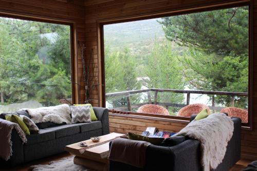 a living room with two couches and a large window at Baker Domo Lodge in Cochrane