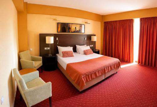 a hotel room with a bed and a chair at Boeme88 in Eforie Sud