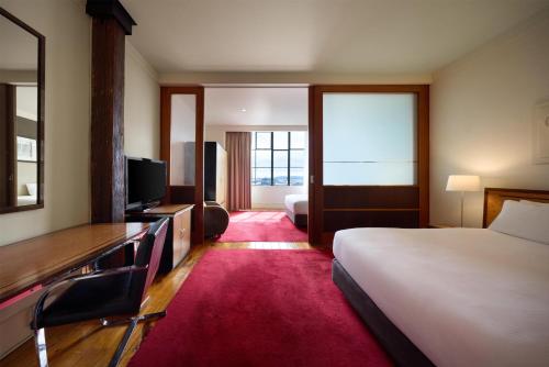 a hotel room with a bed and a television at Rendezvous Heritage Hotel Auckland in Auckland