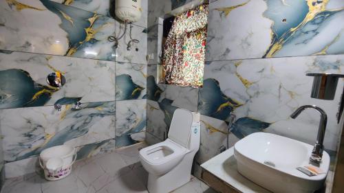 a bathroom with a toilet and a sink at Hotel The Apple Estate in Pahalgām
