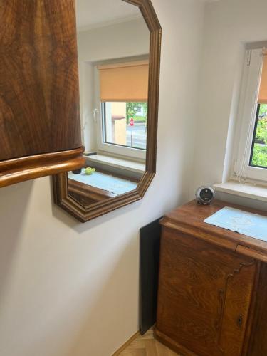 a bathroom with a mirror and a wooden dresser at Emilówka in Ostrów Wielkopolski