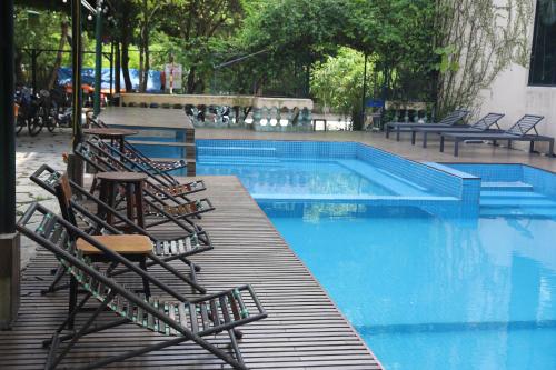 a swimming pool with chairs and a bunch ofitures at Tam Coc Lion Kings Hotel & Resort Ninh Binh in Ninh Binh