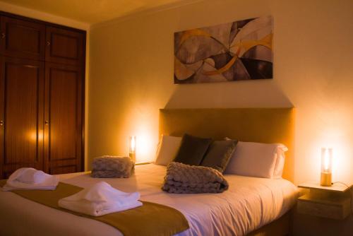 a bedroom with a bed with two towels on it at Moby Dick Guesthouse in Atouguia da Baleia