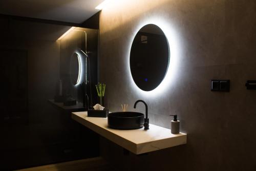 a bathroom with a sink and a mirror on the wall at Moby Dick Guesthouse in Atouguia da Baleia