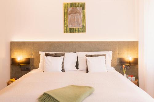 a bed with white sheets and pillows in a room at Apartments GoldRain in Coldrano