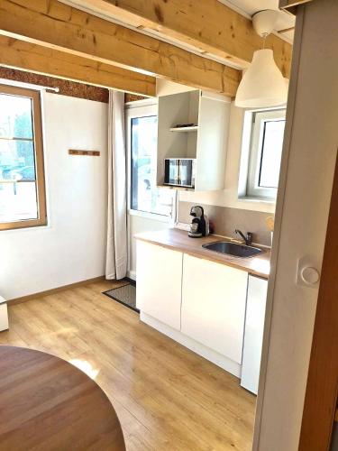 a kitchen with white cabinets and a sink at Cozy Studio in Marck