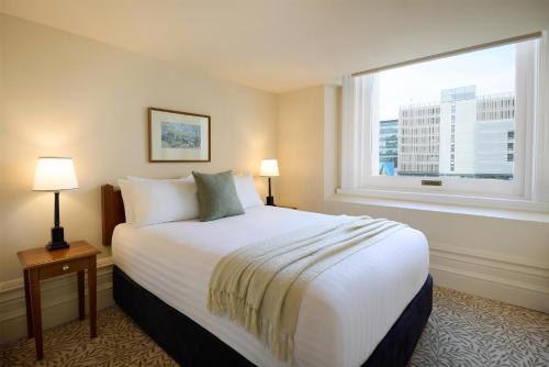 a hotel room with a large bed and a window at Adina Heritage Christchurch in Christchurch