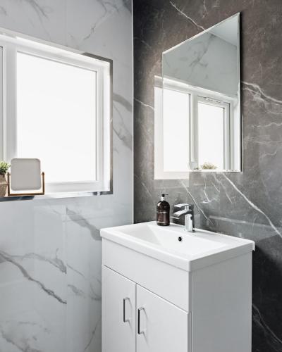 a white bathroom with a sink and a mirror at At Anchor (with a Harbour View) in Fife