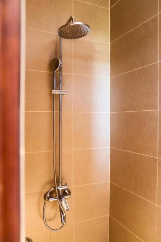a shower with a shower head in a bathroom at HOA GIO Boutique stay in Hue