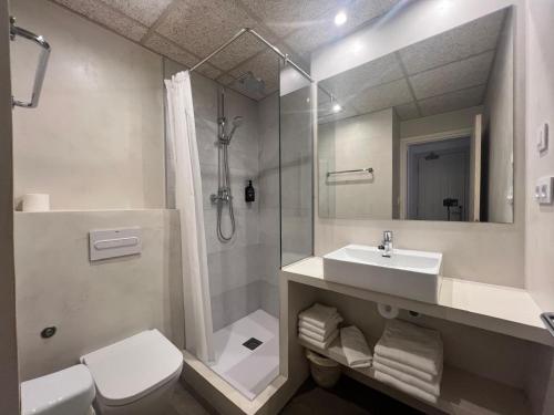 ein Badezimmer mit Toilette, Waschbecken und Dusche in der Unterkunft Hostal ROM Familiar in Roses