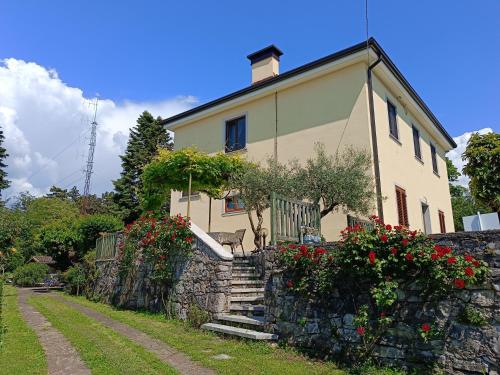 a house with a stone wall and flowers at Residence Ruje in Prepotto