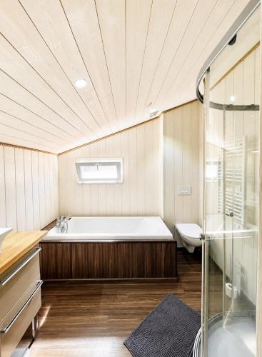 a large bathroom with a tub and a shower at Chalet Familial 6 personnes in Gujan-Mestras