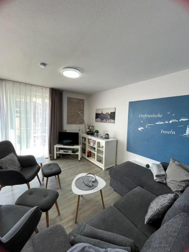a living room with a couch and chairs and a table at Ferienwohnung to Huus in Bensersiel