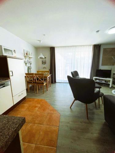 a living room with a kitchen and a dining room at Ferienwohnung to Huus in Bensersiel