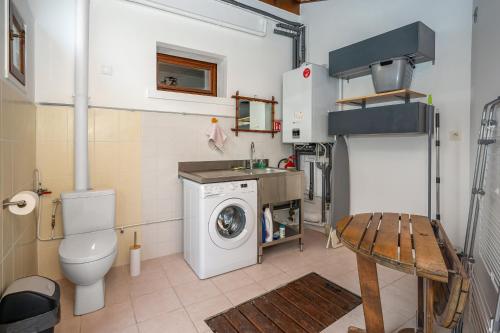 a small bathroom with a washing machine and a washer at Chez Lulu in Brézins