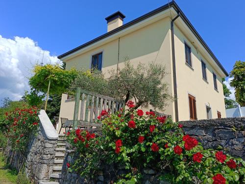 a house with a bench and flowers in front of it at Residence Ruje in Prepotto