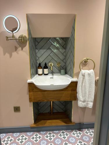 a bathroom with a sink and a mirror at The Lodges @ Barra Castle in Inverurie