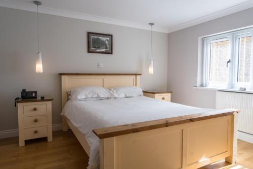 a bedroom with a large bed with white sheets at Finest Retreats - Hollies Coach House in Martock