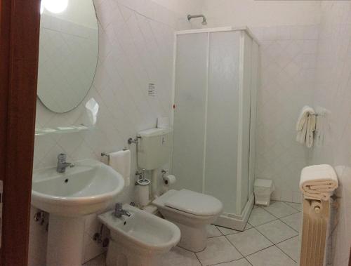 a bathroom with a sink and a toilet and a mirror at Albergo La Posta Arezzo in Badia Al Pino
