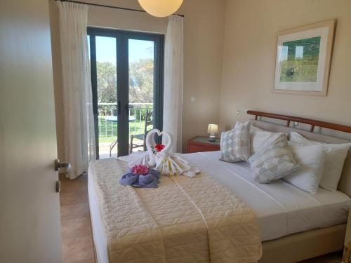 a bedroom with a bed with a stuffed animal on it at Private Pool Villas in Svoronata