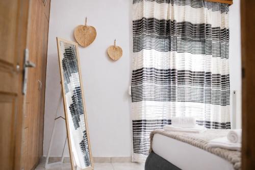 a bathroom with a black and white shower curtain at Indaba Luxury Apartments in Myrina