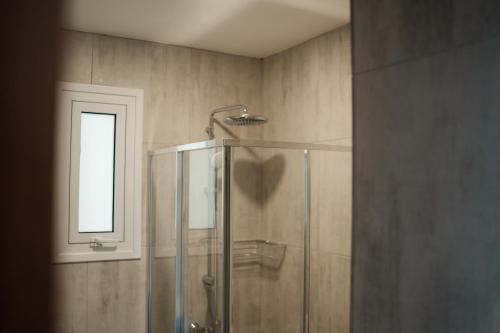 a shower with a glass door in a bathroom at Archontiko Kiverniti in Pano Lefkara