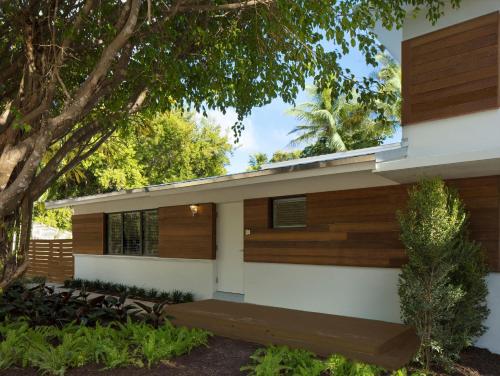 a house with wood paneling and a tree at La Siesta Resort & Villas in Islamorada