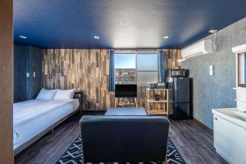 a hotel room with a bed and a couch and a kitchen at Silk Court 201 in Chitose