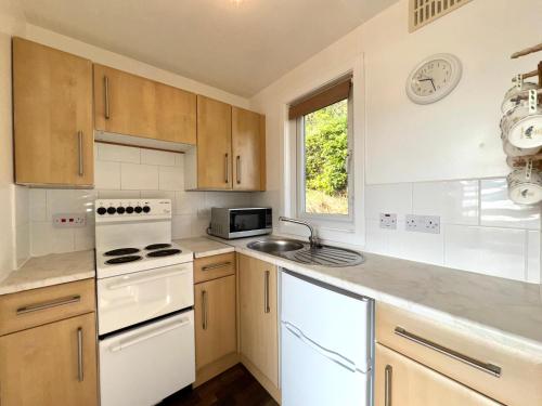 a kitchen with white appliances and a sink at Lochead Chalet 1 in Lochgilphead