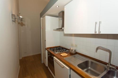 uma pequena cozinha com um lavatório e um fogão em Cosy Little House em Gênova