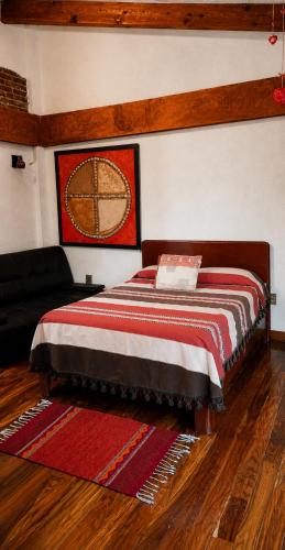 a bedroom with a bed with a red and white blanket at Hotel Frida in Mexico City