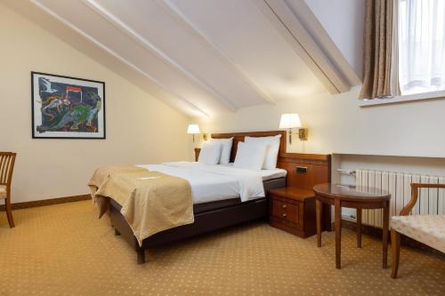 ein Schlafzimmer mit einem Bett, einem Tisch und einem Stuhl in der Unterkunft My City Hotel in Tallinn
