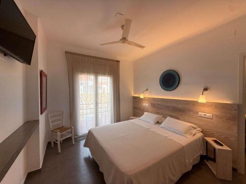 ein Schlafzimmer mit einem weißen Bett und einem Fenster in der Unterkunft Hostal ROM Familiar in Roses