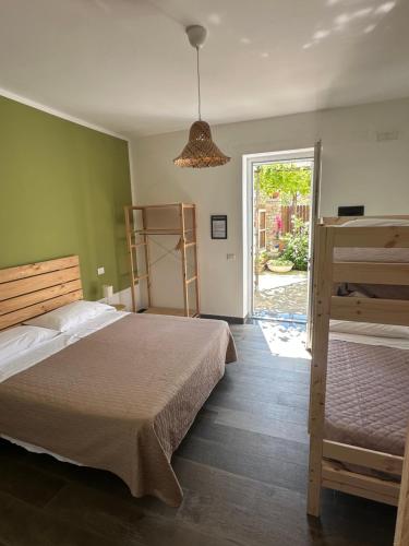 a bedroom with two beds and a sliding glass door at Cilento rooms in Agnone