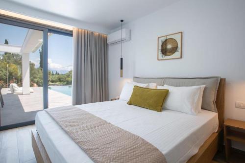a bedroom with a bed with a view of a pool at Amalfi Twins Villa in Nydri