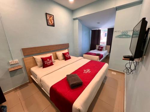 a bedroom with a large bed with a red blanket at Hotel Yasmin in Brinchang