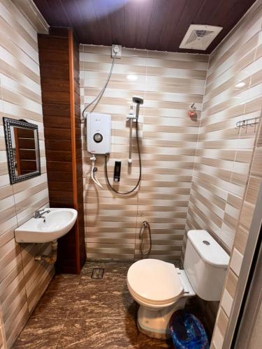 a bathroom with a toilet and a sink at Hotel Yasmin in Brinchang