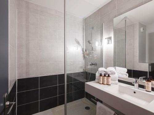 a bathroom with a glass shower and a sink at Hôtel Mercure Lyon Centre Charpennes Parc de la Tête d'Or in Villeurbanne