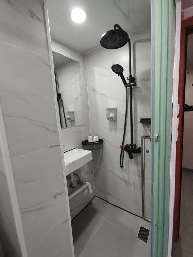 a bathroom with a shower and a sink at Ocean Inn in Hong Kong