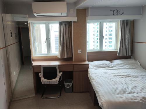 a bedroom with a desk with a bed and a chair at Ocean Inn in Hong Kong