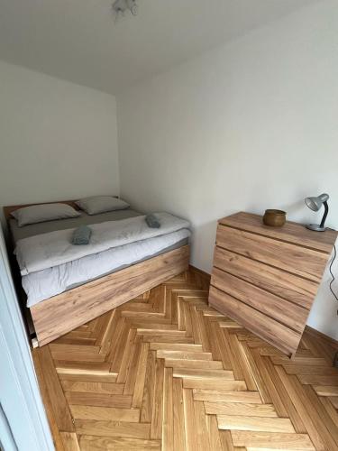 a bedroom with a bed and a wooden floor at Sweet Escape Pécs in Pécs