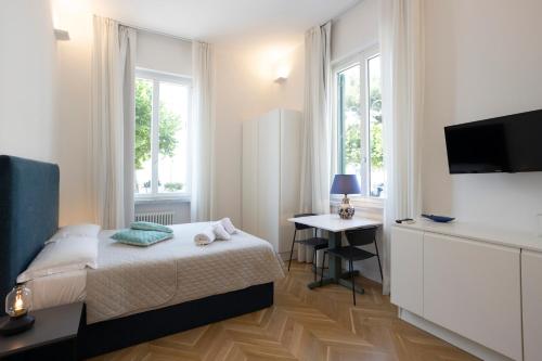 a bedroom with a bed and a television and a desk at SINONDA Luxury Apartment in Maiori