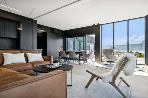 a living room with a couch and a table at Lyngvær Arctic Pearl Lodge - Jacuzzi & Sauna - No 17 in Kleppstad