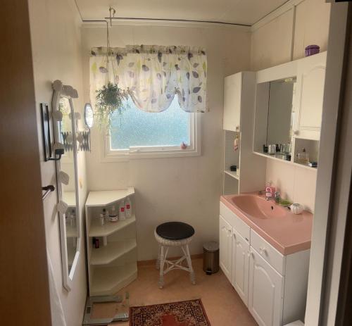 a white bathroom with a sink and a window at Spacious house in cozy Kristdala in Kristdala